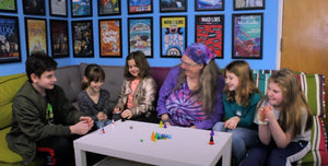 Kristin Looney playing Pyramid games with children seated on a bench around a white table