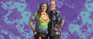 Kristin and Andy Looney posing with a purple and teal tie dye background